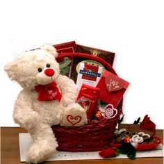 a white teddy bear sitting in a basket filled with valentine's treats and candy