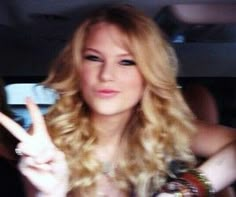 a woman sitting in the back seat of a car making a peace sign with her fingers