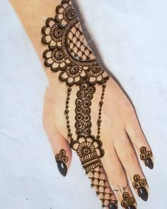 a henna tattoo on the hand of a woman with dark nails and black nail polish