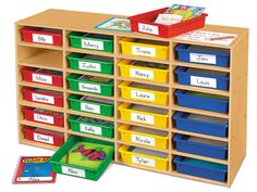 a large wooden shelf filled with lots of different colored bins and books on top of it