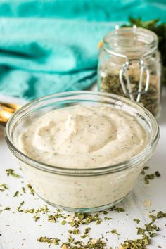 two jars filled with dressing sitting on top of a table