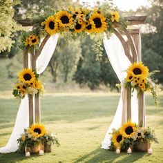 sunflowers and greenery decorate an outdoor ceremony arch