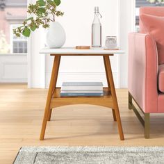 a living room scene with focus on the end table and pink chair in the background