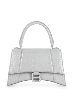 light grey calfskin embossed crocodile effect signature B logo plaque adjustable detachable shoulder strap single rounded top handle foldover top with magnetic fastening We've partnered with Good On You — an independent agency that rates how brands perform in relation to their impact on the planet, people and animals, with a multi-criteria rating simplified to a five points scale. In order to be awarded our conscious label, larger brands need to score a minimum of four out of five ('Good'), while smaller brands must score at least three out of five ('It's a start'). This item comes from a brand rated four out of five ('Good') by Good on You at the time it was added on FARFETCH. Please note, this is a brand-level rating and does not guarantee that this product is made with conscious materia B Logo, Miu Miu Bag, Structured Bag, Balenciaga Bag, Crocodile Leather, Dolce E Gabbana, Small Handbags, Tote Bag Design, Grey Leather