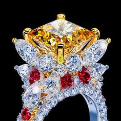 a fancy yellow diamond ring with red and white stones on it's sides, surrounded by smaller diamonds