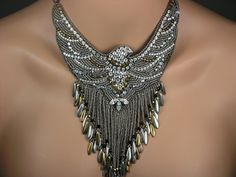 an elaborate necklace is displayed on a mannequin's neckline, with gold and silver beads