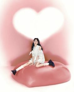 a woman sitting on top of a heart shaped object