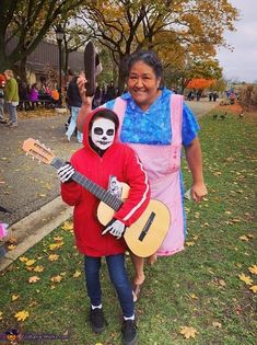 two people in costumes are holding guitars and smiling