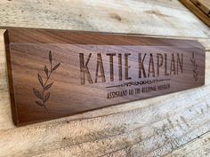 a wooden sign with the name kate kaplan on it