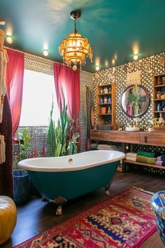 a bath tub sitting on top of a wooden floor next to a rug and window