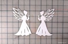 two paper cut outs depicting the silhouettes of fairy tale characters, one holding a flower