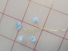 a piece of wire with blue beads on it sitting on top of a tile floor