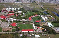 an aerial view of a large field with many buildings and trees in the foreground