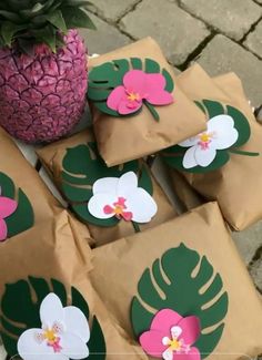 some brown paper bags with pink and white flowers on them next to a pineapple