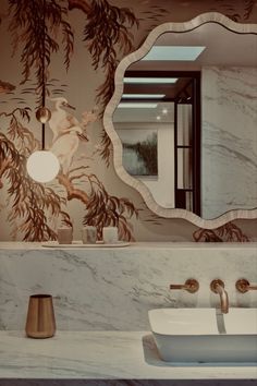 a bathroom with marble counter tops and gold faucets on the sink, along with a mirror