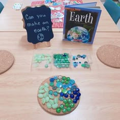 the table is set up with different colored beads and books for each child to read