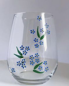 a glass with blue flowers painted on it