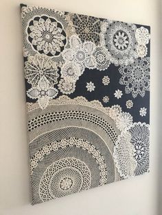 a black and white wall hanging on the side of a wall next to a window