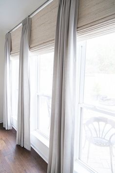 a living room with white curtains and wood floors