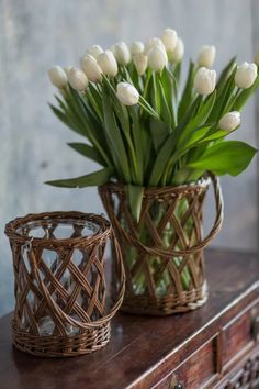 two wicker baskets with white tulips in them