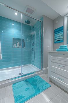 a bathroom with blue tiles and white furniture in the shower area, along with a rug on the floor