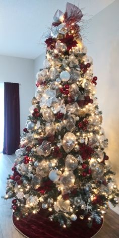 a white christmas tree with red and silver ornaments