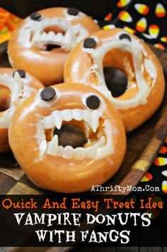 four doughnuts with fake teeth and googly eyes are on a wooden platter