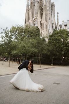 a bride and groom kissing in front of the saffroniss cathedral, barcelona