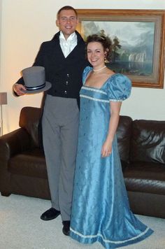 a man and woman dressed in period clothing posing for a photo with a hat on their head