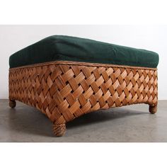 a footstool made out of wicker with green cushion on the top and bottom