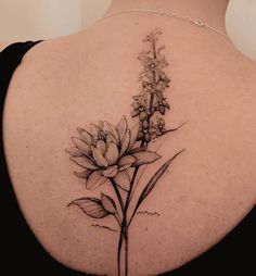 the back of a woman's shoulder with flowers and leaves on her left side