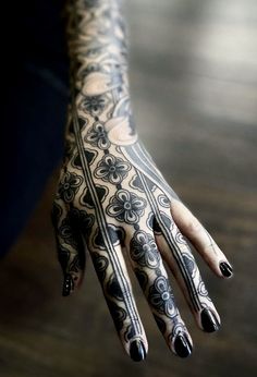 a woman's hand with black and white tattoos on it