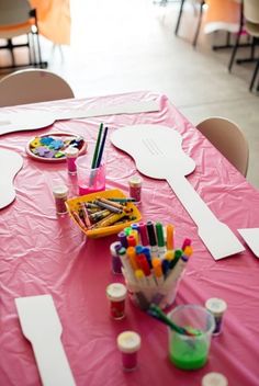 the table is set up with markers, crayons and paper plates