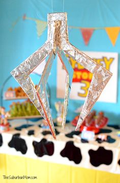 an ornament made out of tin foil sitting on top of a table covered in candy