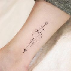 a woman's foot with an arrow tattoo on it