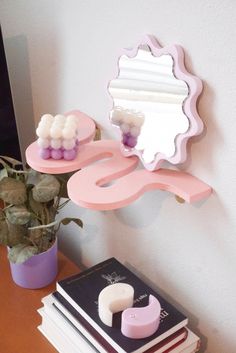 there is a mirror and some books on the table next to each other with soaps in front of it