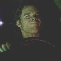 a man driving in the dark with his eyes wide open and tongue hanging out,