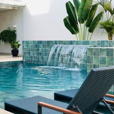 two lounge chairs sitting in front of a swimming pool