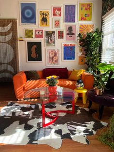 a living room filled with furniture and lots of pictures on the wall above it's coffee table