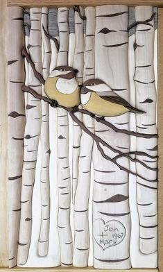 two birds sitting on top of a tree branch in front of some white birch trees