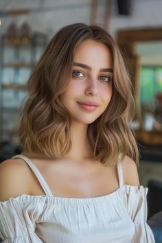 Smiling woman with shoulder-length wavy hair, wearing an off-shoulder white top. Haircolors Warm Skin, Hair Color For Neutral Warm Skin Tone, Autumn Hair Highlights, Hair Color For Warm Autumn Skin Tone, Honey Brown Hair Fair Skin, Cinnamon Lowlights, Chestnut Brown Hair Fair Skin, Neutral Skin Tone Hair Color, Soft Autumn Hair