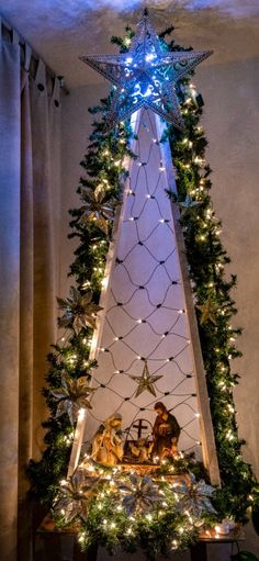 a christmas tree is decorated with lights and garlands in the shape of a star