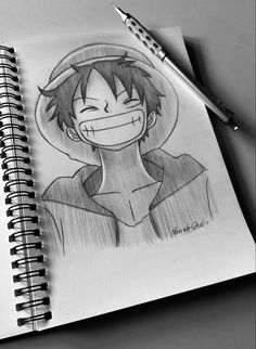 a drawing of an anime character with a smile on his face and head, next to a pen