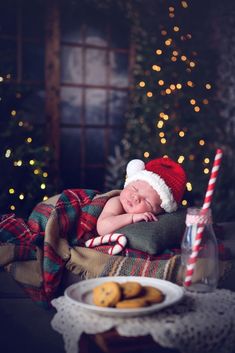 a baby sleeping on top of a blanket next to cookies