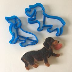 two cookie cutters shaped like dogs on a white table with one dog and the other is a dachshund