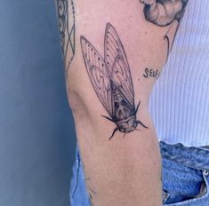 a close up of a person's arm with a tattoo on it and a butterfly