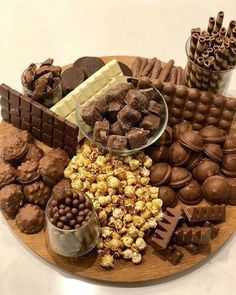 a wooden platter filled with lots of chocolates and candies on top of a table