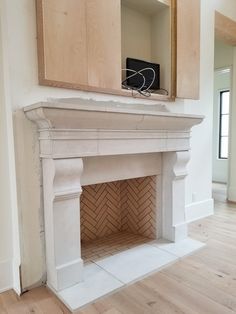 an empty room with a fireplace and cabinets