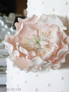 a white and pink wedding cake with flowers on it