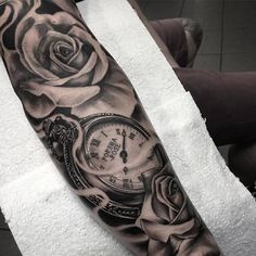 a black and white photo of a rose with a pocket watch tattoo on the arm